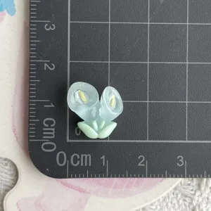 Mini fleur en résine transparente accessoire de bricolage détail sur tapis quadrillé