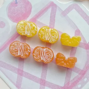 Gedetailleerd aanzicht van kleine half-3D hars sinaasappelhangers voor nail art en decoratie.