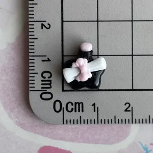 Mini black resin bow bottle craft charm detail view showing size on measurement grid