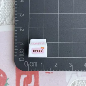 Mini Harz Brot Karton Anhänger Nahaufnahme, zeigt detailliertes Design auf Rastermatte.