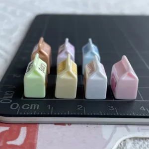 Nahaufnahme bunter Mini-Harz-Milchkarton-Anhänger, ideal für DIY-Bastelarbeiten und Handydekoration.