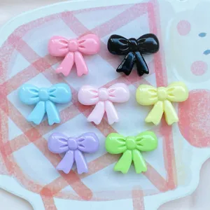 Mini resin bow cabochons in assorted colors for DIY nail art, hair clips, and jewelry crafts.