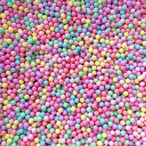 Perles rondes sans trou aux couleurs macaron bonbon en gros plan pour remplissage et boite.