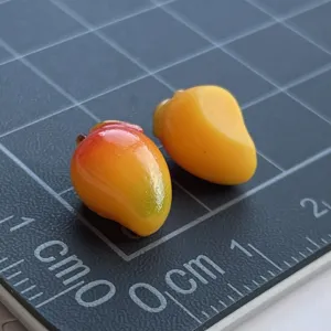 Dettaglio ciondolo mango in resina in miniatura, perfetto per custodia telefono e mini giocattolo.