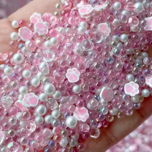 Close-up detail of mixed pink bubble beads, white pearls, and cute cat paw slime charms.