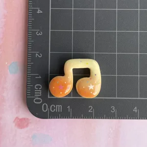 Resin music note charm detail, colorful star pattern, perfect for DIY phone case decor.
