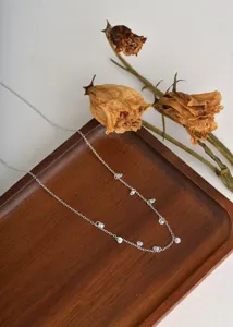 Detailed close-up of a delicate silver-tone station necklace featuring sparkling cubic zirconia.