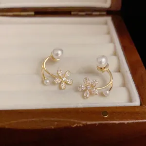 Vista detallada de pendientes de flores de perlas plata s925, circón elegante y diseño fino.