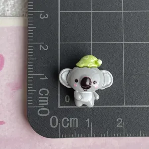 Mini resin koala charm with green hat detail shot, perfect for DIY crafts and accessories.