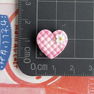 Rosa kariertes Herz Resincharm mit weissem Blumen, Miniatur DIY Basteln Cabochon Detailansicht.