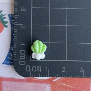 Dettaglio ciondolo in resina cavolo miniatura su tappetino per nail art e accessori fai da te.