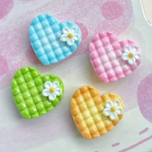 Detailansicht von bunten Mini Karree Herz Harz Cabochons mit süßen weißen Blumen Anhängern.