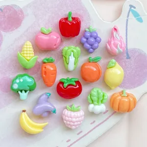 Primo piano dettagliato di simpatici ciondoli in resina di frutta e verdura per nail art e fai da te.