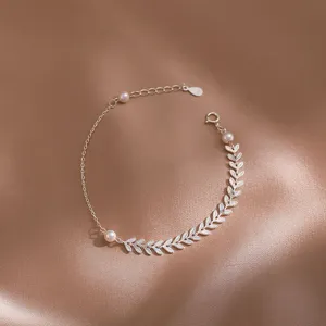 Vista detallada del elegante tobillero de plata S925 con perlas y hojas delicadas.