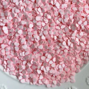 Gros plan de tranches de pâte polymère en forme de cœur rose et blanc pour loisirs créatifs.