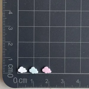 Gros plan de charms nuages en argile, accessoires miniatures mignons pour déco de coque.