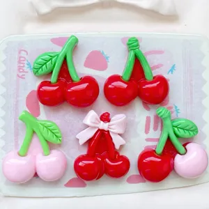 Close-up detail of cute resin cherry cabochons with bow, perfect for DIY phone case decor.