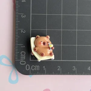 Cute cartoon resin capybara detail shot showing compact size on measurement grid mat.