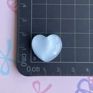 Resin glitter heart charm detail showing size on ruler, perfect for DIY phone case crafts.