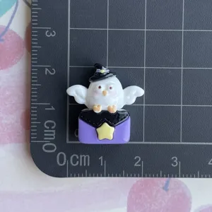 Detailed shot of Halloween ghost resin cabochon, cute witch hat design for DIY phone case craft.