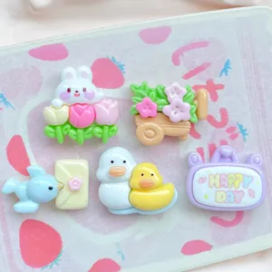 Detalle de dijes bonitos de resina flor conejo pato para manualidades y decoración de celular.
