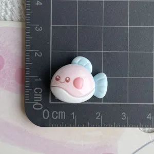Detailed close-up of cute resin fish charm in pink and blue, perfect for DIY craft and accessories.