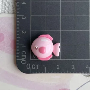 Close up of cute pink fish resin cabochon craft accessory, perfect for DIY decoration.