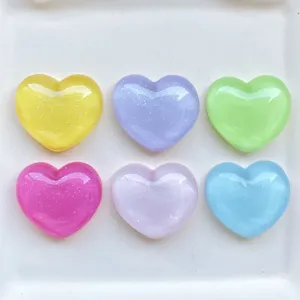Close up of colorful resin heart charms with glitter, great for DIY phone and hair decor.