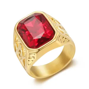 Primo piano di un anello massonico da uomo dorato con una grande pietra rossa.