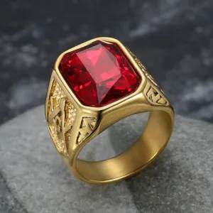 Vista ravvicinata di un anello da uomo in oro con una grande gemma rossa sfaccettata