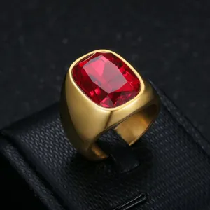 Macro detail showing the facets of a red cushion-cut zircon set in a gold stainless steel ring.
