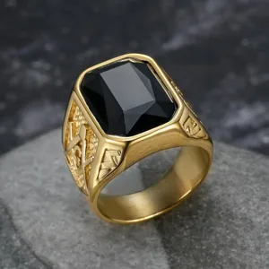 Dettaglio di un anello massonico in acciaio dorato con grande pietra nera sfaccettata