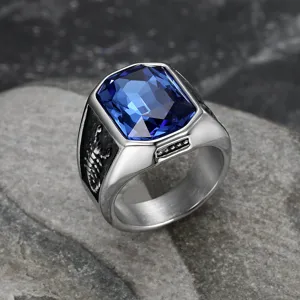 Dettaglio di un anello da uomo in acciaio inox con gemma blu e motivo a scorpione