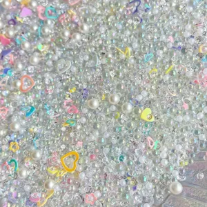 Detailed shot of mixed DIY craft beads, iridescent rhinestones, and cute pastel resin charms.
