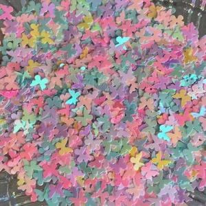 Primo piano dettagliato di ciondoli in resina perlata a forma di farfalla colorata per bricolage.
