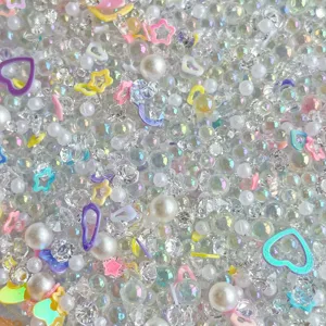 Mixed DIY craft beads pearls resin hearts and iridescent diamonds for phone case decoration.