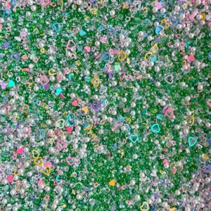 Mixed DIY craft beads pearls rhinestones and colorful heart sequins for slime and resin phone decor.