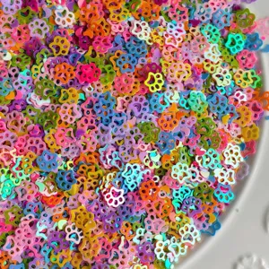 Primo piano di paillettes colorate a forma di zampa, ideali per lavori artigianali fai-da-te e resina.