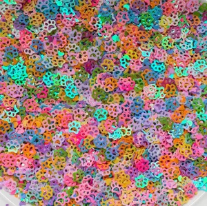 Primo piano dettagliato di paillettes artigianali colorate a forma di zampa, glitter.