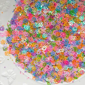 Primo piano di paillettes colorate a forma di zampa, ideali per fai-da-te e nail art.