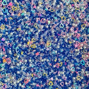 Mixed DIY craft accessories featuring blue beads, white pearls, and cute pastel heart charms.