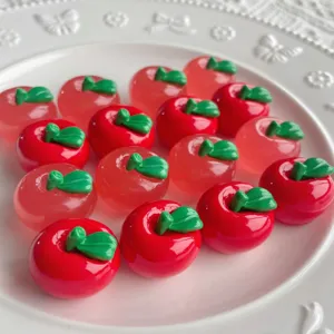 Primo piano dettagliato di ciondoli in resina a forma di mela rossa per custodie fai da te e forcine.