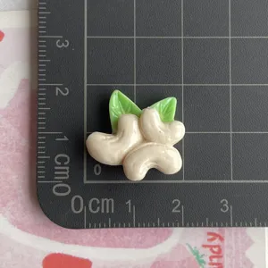 Breloque noix de cajou feuille verte en résine pour coque de téléphone DIY détail.
