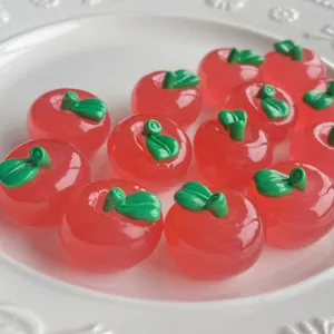 Primo piano dettagliato di ciondoli in resina a forma di mela rossa trasparente per fai da te.
