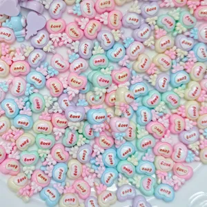 Close-up of colorful heart resin flatbacks, pastel DIY craft accessories for decoration.