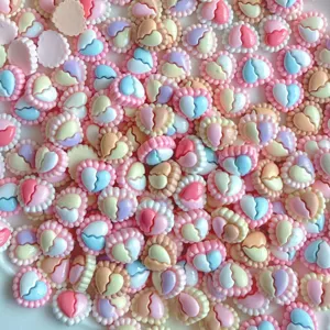 Close-up detail of colorful pastel resin heart charms for DIY nail art and jewelry making.