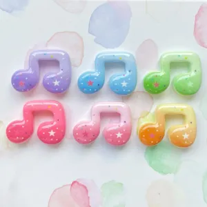 Close-up of colorful resin musical note charms with star patterns for DIY crafts and phone case decoration.