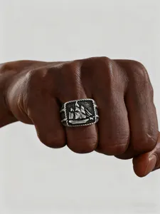 Detailed macro view of vintage stainless steel men's ring with a sailboat design on hand