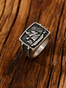 Macro view of vintage stainless steel sailing ship ring with embossed nautical details