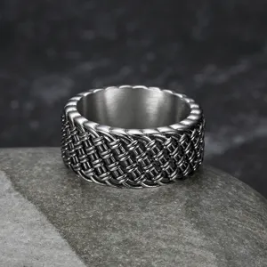 Detailed macro view of a vintage braided stainless steel punk ring for men on stone